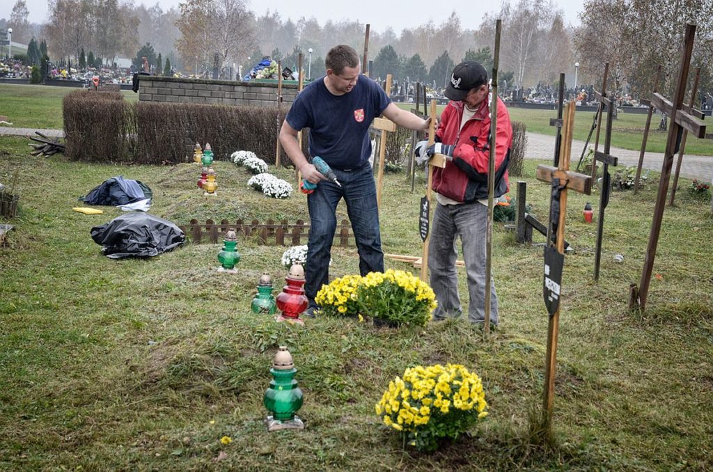 Bezdomni porządkują zaniedbane groby